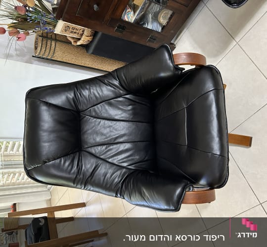 כורסה מרופדת עור שחור עם רגלי עץ